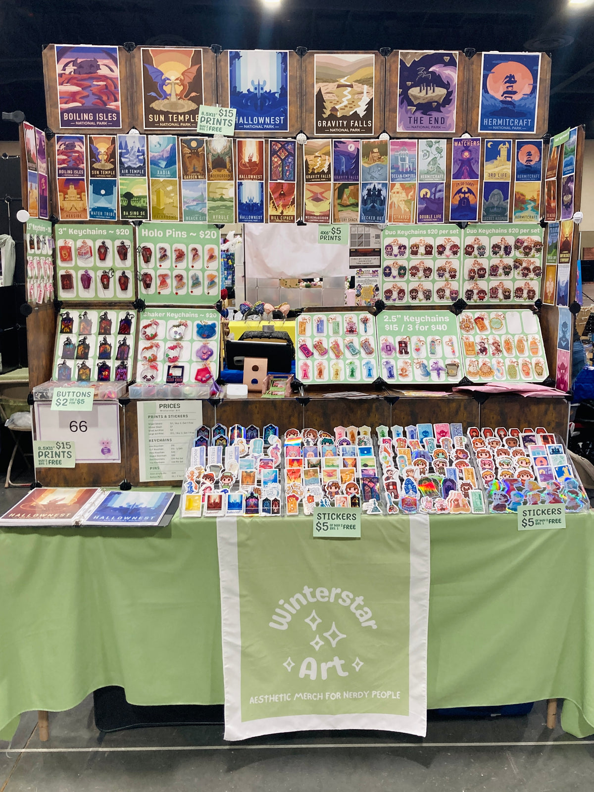 Stall with various merchandise including books, stickers, and other items at a convention.